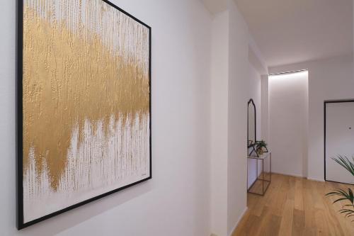 a large gold painting on a wall in a hallway at Missori Luxury Apartments in Milan