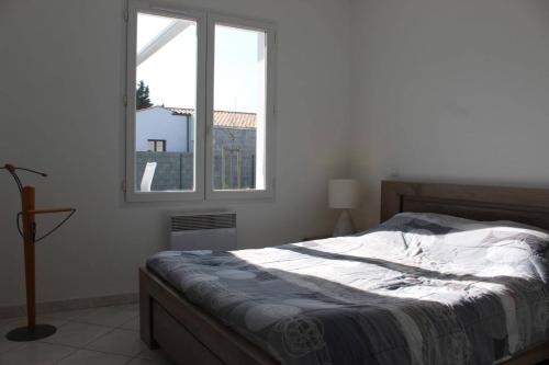 une chambre avec un lit et une fenêtre dans l'établissement Maison 3 pièces 5 couchages Saint Pierre d'Oléron SPO000-039, à Saint-Pierre-dʼOléron