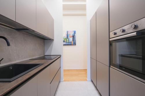 a kitchen with white cabinets and a sink at Missori Luxury Apartments in Milan