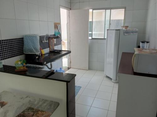 eine Küche mit einem Kühlschrank und einem weißen Fliesenboden in der Unterkunft Espaço Vila Verde in Paulista