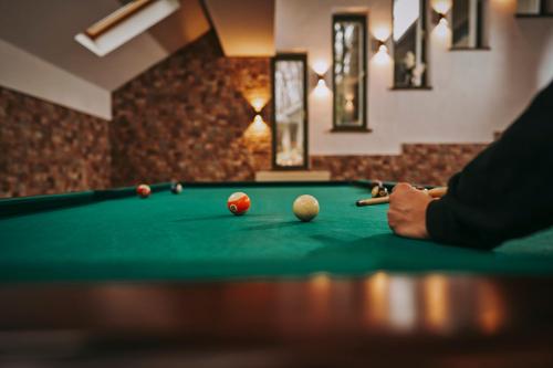 a man playing billiard with a cue on a pool table at Hotel & Restaurant Sofia in Suceviţa