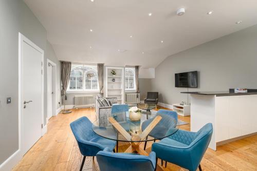 a living room with a table and blue chairs at Destiny Scotland - St Andrew Square Apartments in Edinburgh