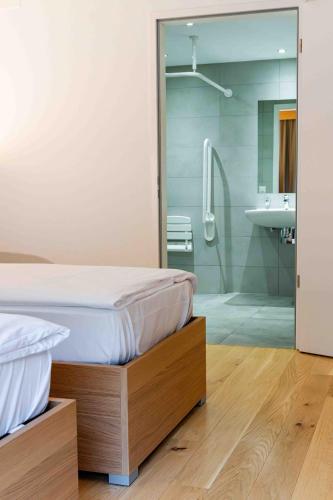 a bedroom with a bed and a shower and a sink at Los Lorentes Apartments Bern City in Bern