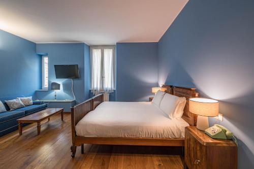 a bedroom with blue walls and a bed and a couch at Antica Locanda Leonardo in Milan