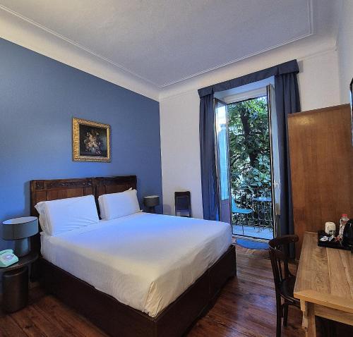 a bedroom with a bed and a table and a window at Antica Locanda Leonardo in Milan