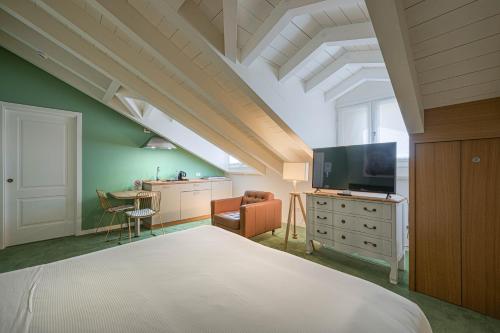 a bedroom with a bed and a tv and a desk at Antica Locanda Leonardo in Milan