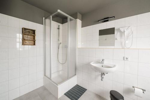 a bathroom with a shower and a sink at Wombat's City Hostel Leipzig in Leipzig