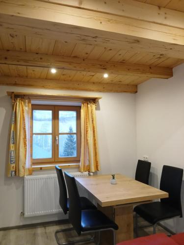 a dining room with a wooden table and chairs at Ferienwohnung Moharblick 1 in Großkirchheim