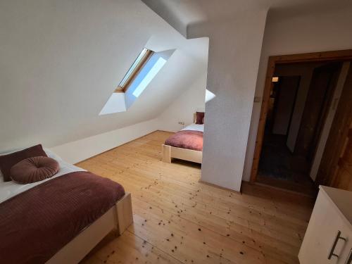 a attic bedroom with two beds and a window at Ferienhaus Stadt Juwel in Mürzzuschlag