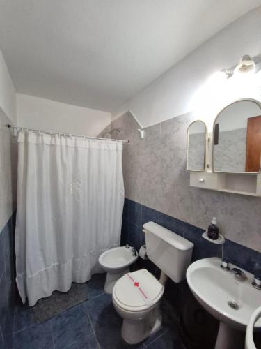 a bathroom with a white toilet and a sink at Cabañas Brochero del Valle in Villa Cura Brochero