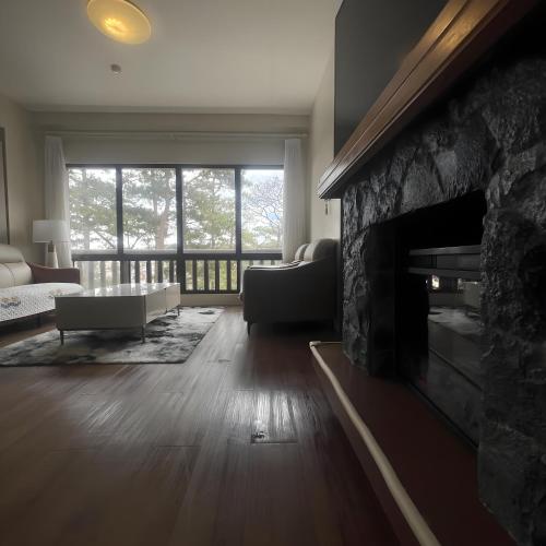 a living room with a stone fireplace and a couch at 163 Sqm Luxury Spacious Modern European Cott-age Style 3 Bedrooms With 2 Parkings in Baguio