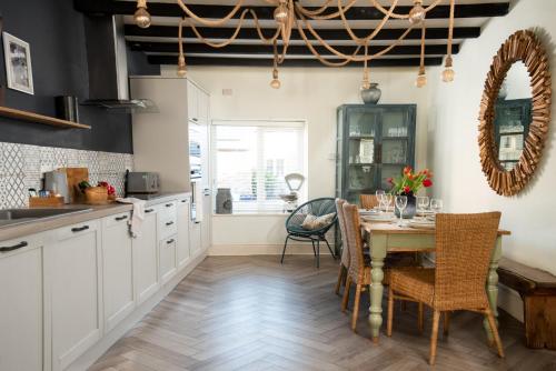 a kitchen with a table and chairs and a dining room at Harbour Way Cottage by Coast & Country Stays in Seahouses