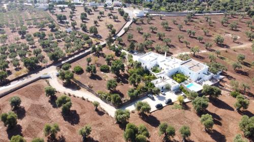 an aerial view of a large white house with trees at Masseria Stefanodelconte in Torre Canne