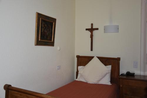 a bedroom with a bed with a cross on the wall at Casa Santa Birgitta in Lugano