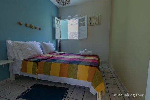 una camera da letto con un letto con una coperta colorata di Pertinho do Mar a 300m, 1 Quarto, Comércio Próximo a Marechal Deodoro