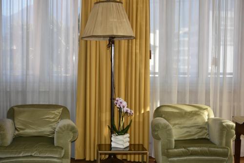 a living room with two chairs and a floor lamp at Casa Santa Birgitta in Lugano