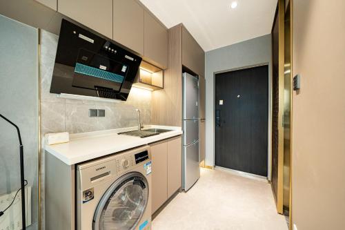 a kitchen with a washing machine and a sink at Today Aparthotel West Lujiazui Shanghai in Shanghai