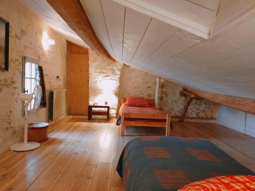 una camera mansardata con letto e tavolo di Maison d'Orion a La Réole