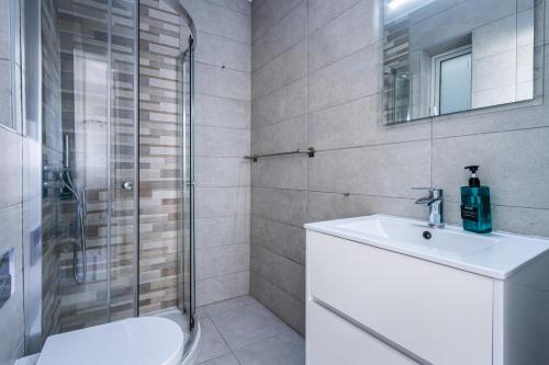 a bathroom with a toilet and a sink and a shower at Bright and modern apartment in St Julian's