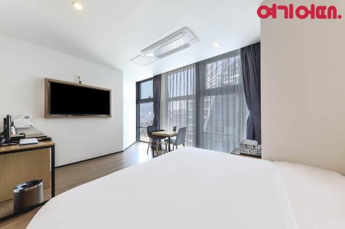 a hotel room with a bed and a flat screen tv at Gwanganri HOTEL OCEANVIEW in Busan