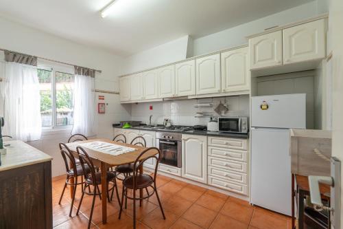 a kitchen with white cabinets and a table and chairs at VillaHouse in São Vicente