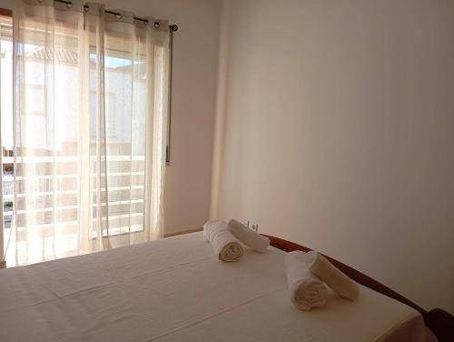 Un dormitorio blanco con una cama con toallas. en Villa Cacela Mar, en Vila Nova de Cacela
