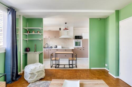 une cuisine avec des murs verts et une table et des chaises dans l'établissement Stunning 1BR flat 10 min from the Eiffel Tower, à Paris