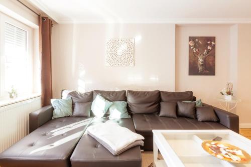 a living room with a brown couch and a table at Ferienwohnungen Ziesing in Thale