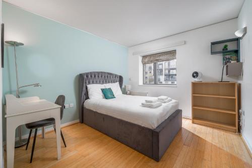 a bedroom with a bed and a desk and a table at Lovely 3BD Flat, Parking, sleeps SIX close to O2 in London