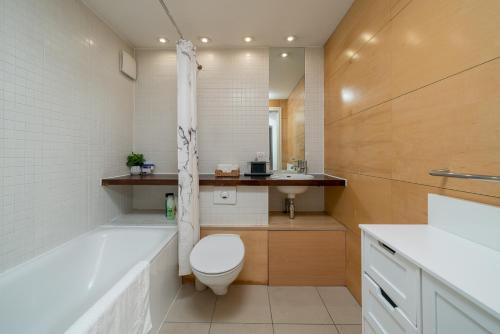 a bathroom with a toilet and a tub and a sink at Lovely 3BD Flat, Parking, sleeps SIX close to O2 in London