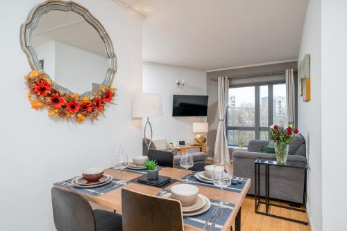 a living room with a table and a mirror at Lovely 3BD Flat, Parking, sleeps SIX close to O2 in London
