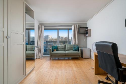 a living room with a couch and a window at Lovely 3BD Flat, Parking, sleeps SIX close to O2 in London