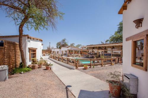 a resort with a swimming pool and a building at Hotel La Cochera in San Pedro de Atacama