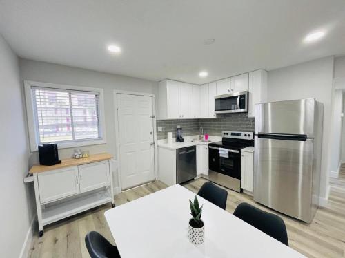 a kitchen with white cabinets and a table and a refrigerator at Perfect Vacation walk to the beach 9 in Myrtle Beach