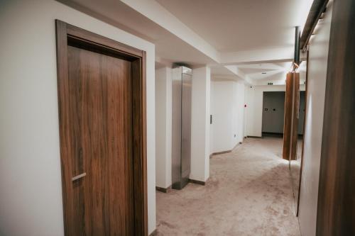 a hallway with a wooden door in a room at Hotel Bavka in Leskovac
