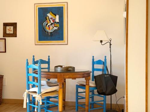 a dining room with a table and blue chairs at La Casita Azul - 1004 in Arnuero