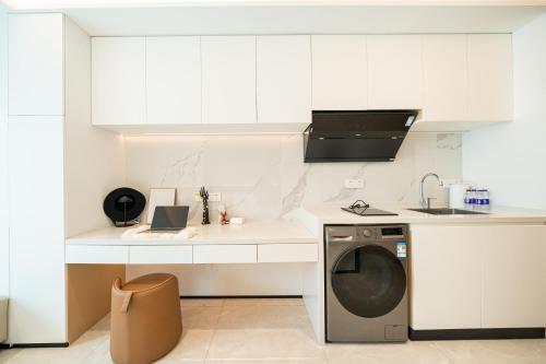 a white kitchen with a washing machine in it at Today Aparthotel West Lujiazui Shanghai in Shanghai