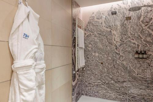 a towel hanging on a wall in a bathroom at NH Catania Centro in Catania