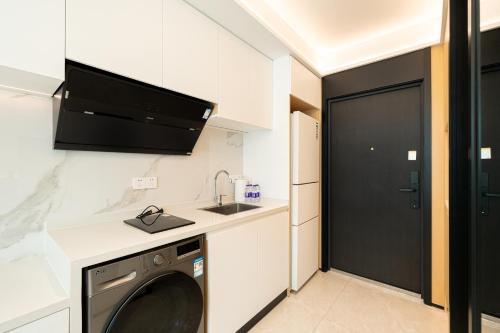 a laundry room with a sink and a washing machine at Today Aparthotel West Lujiazui Shanghai in Shanghai