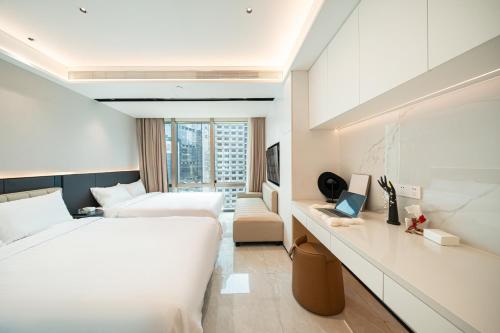 a hotel room with a large bed and a desk at Today Aparthotel West Lujiazui Shanghai in Shanghai