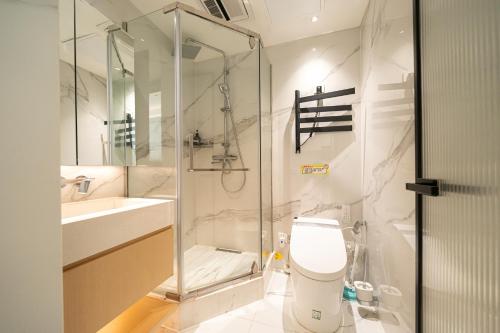 a bathroom with a toilet and a glass shower at Today Aparthotel West Lujiazui Shanghai in Shanghai