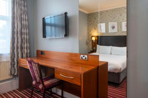 a hotel room with a desk and a bed at London Croydon Aerodrome Hotel, BW Signature Collection in Croydon