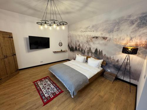 a bedroom with a bed and a painting on the wall at Zen Retreat Apartment in Sinaia