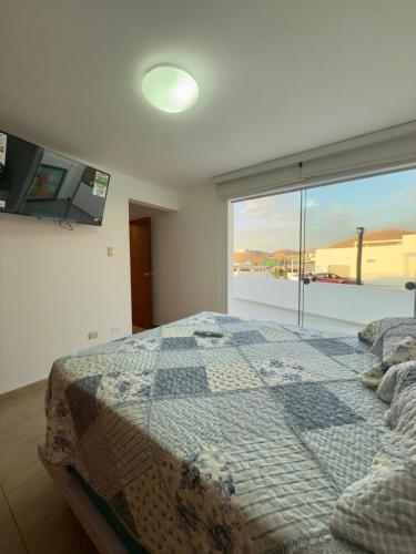 a bedroom with a bed and a large window at Beach house Sol Mar y Relax in Cerro Azul