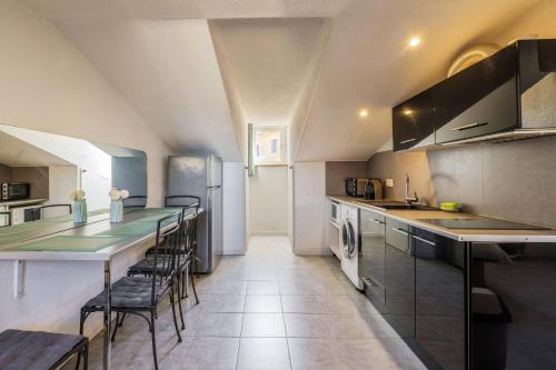 - une cuisine avec un grand comptoir et des chaises dans l'établissement Perchoir dans la vieille ville, à Nice