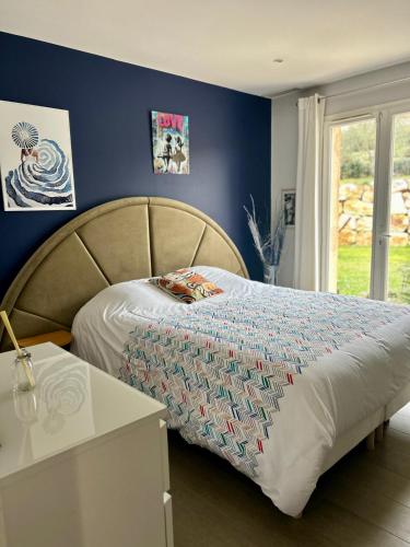 une chambre avec un lit et un mur bleu dans l'établissement Pretty air conditioned villa, à Mouans-Sartoux