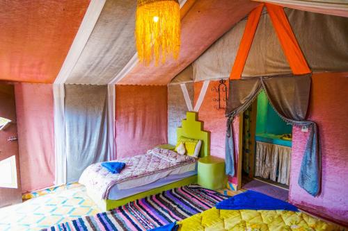 a bedroom with a bed in the middle of a room at Sahara Garden Luxury Camp in Merzouga