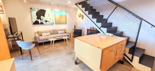 a living room with a staircase and a couch at Elegant Townhome in Heart of Down Town in Albuquerque
