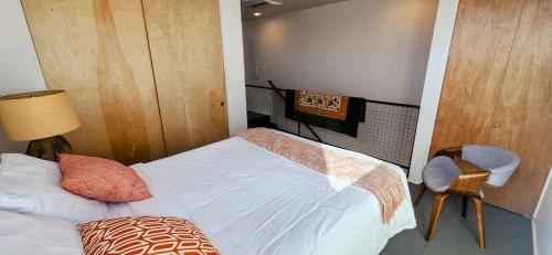 a small bedroom with a bed and a chair at Elegant Townhome in Heart of Down Town in Albuquerque