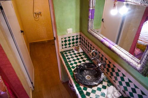 a bathroom with a toilet with a checkered floor at Sahara Garden Luxury Camp in Merzouga